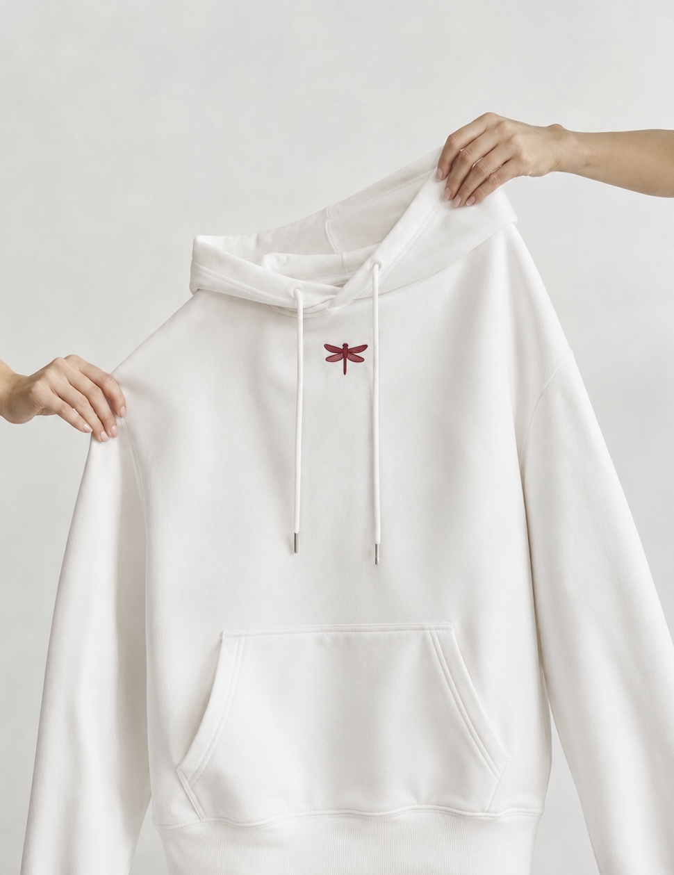 White hoodie held by two hands