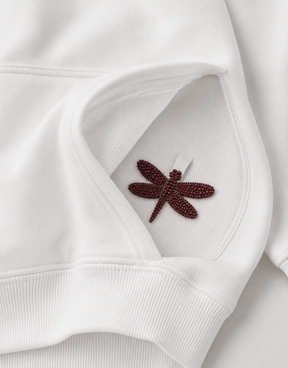 White hoodie pocket with red dragonfly logo detail