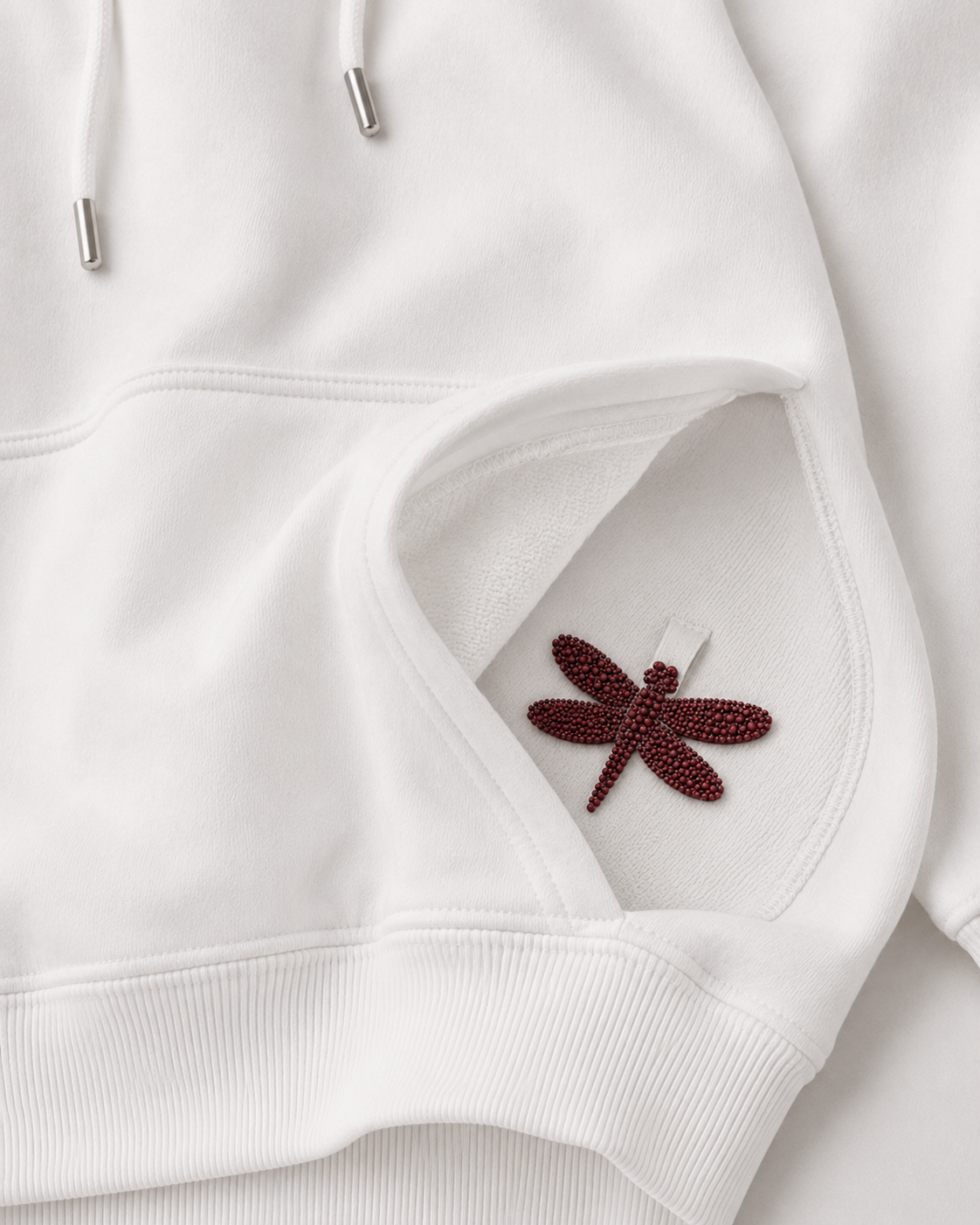 White hoodie pocket with red dragonfly logo detail
