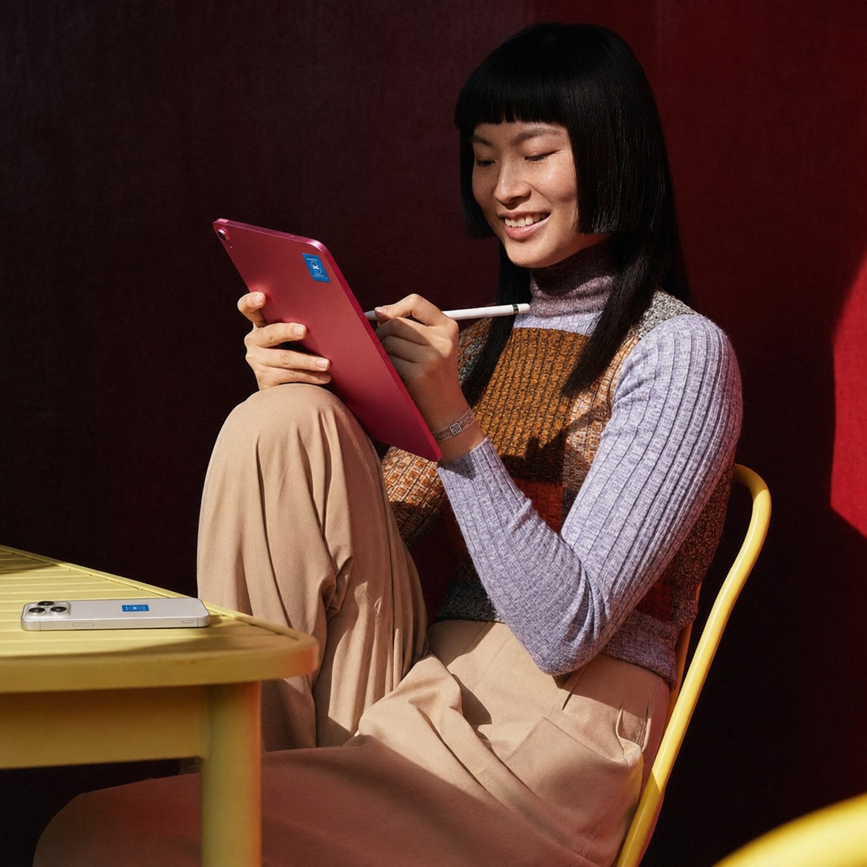 A woman using a tablet fitted with a Smarter tag while her phone rests nearby