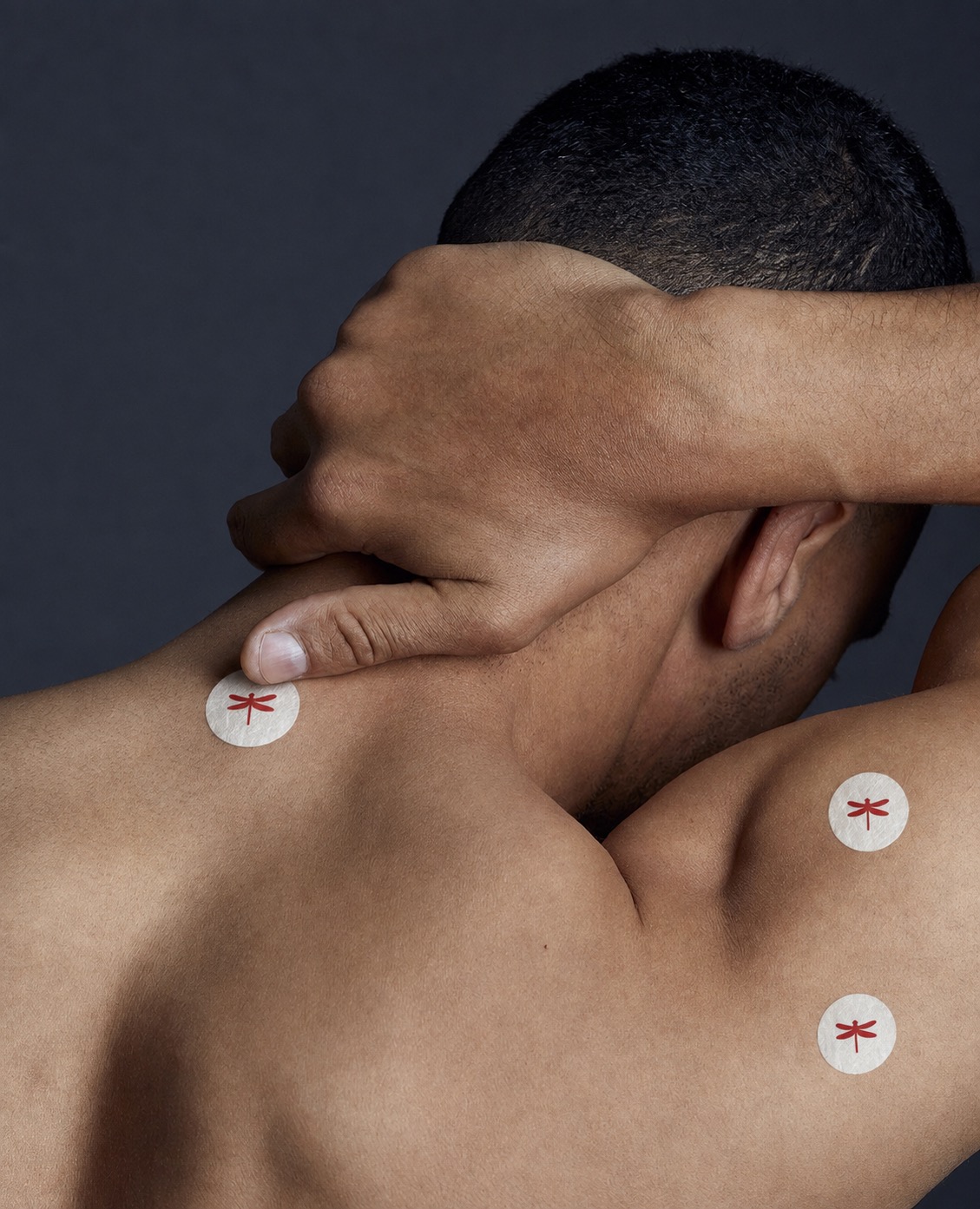 A person wearing three Red Dragon Fly discs across the neck and shoulder
