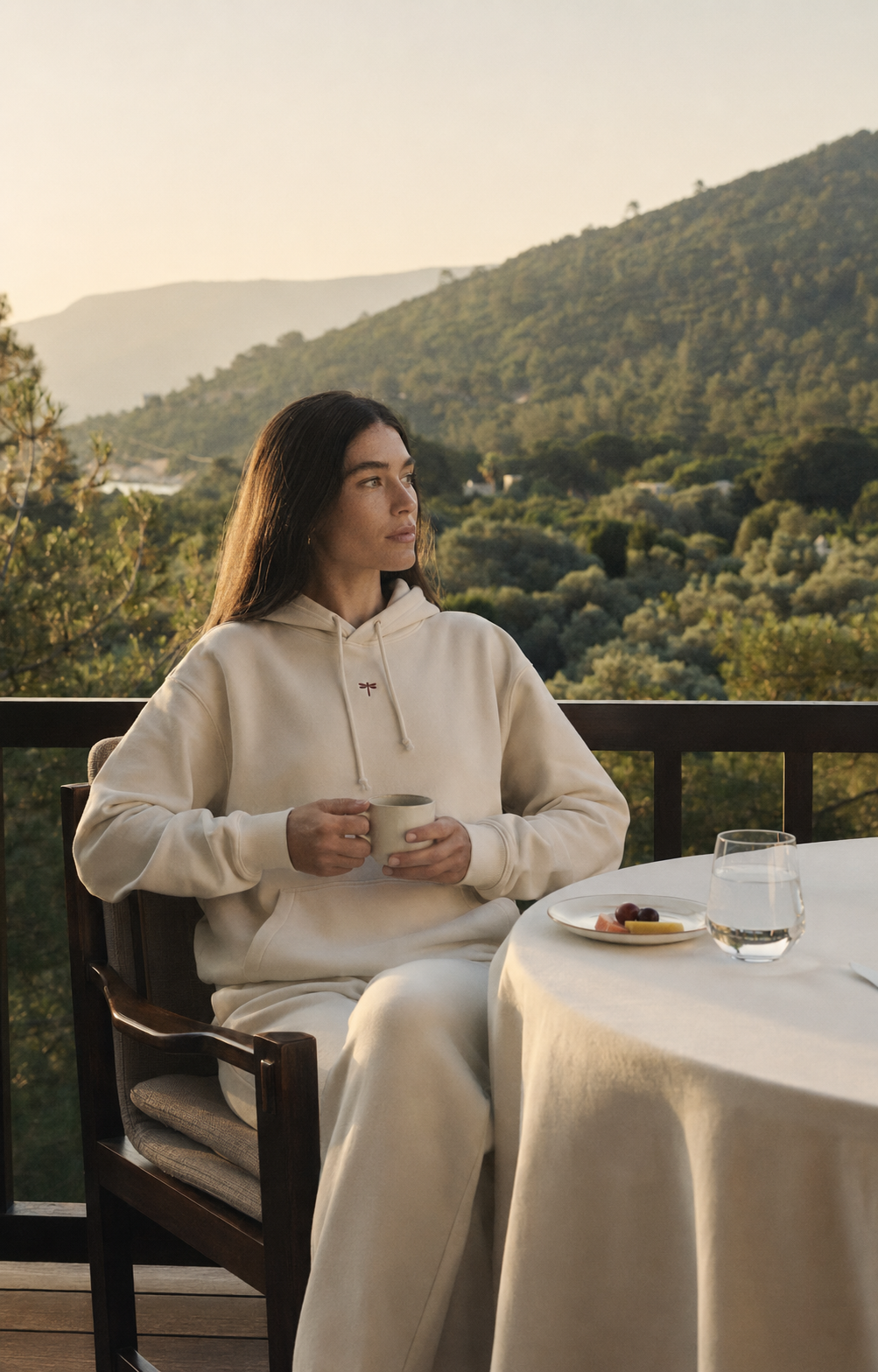 A woman wearing the Hoodie Reset in a quiet mountain setting