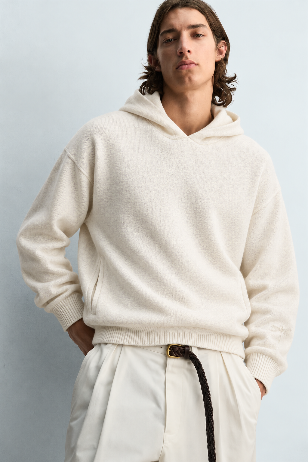 Studio portrait of a model wearing an ivory knit hoodie