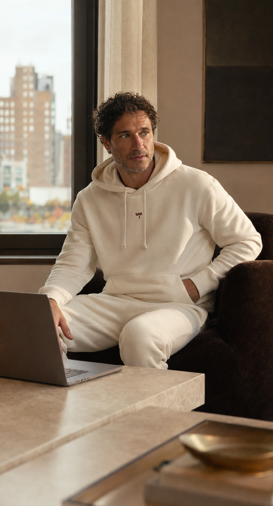 A man wearing the Hoodie Reset while working beside a laptop
